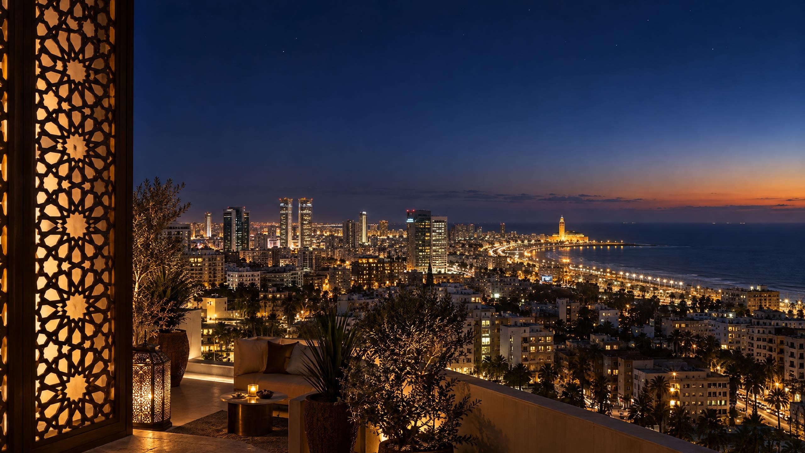 Casablanca à l’heure bleue depuis une terrasse : un moucharabieh aux étoiles à huit branches éclairé de l’intérieur, les tours du centre et la corniche illuminées jusqu’à la mosquée Hassan II
